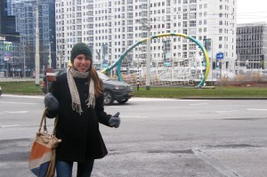 Laimīga Kate ar lielu tenisa raketi fonā